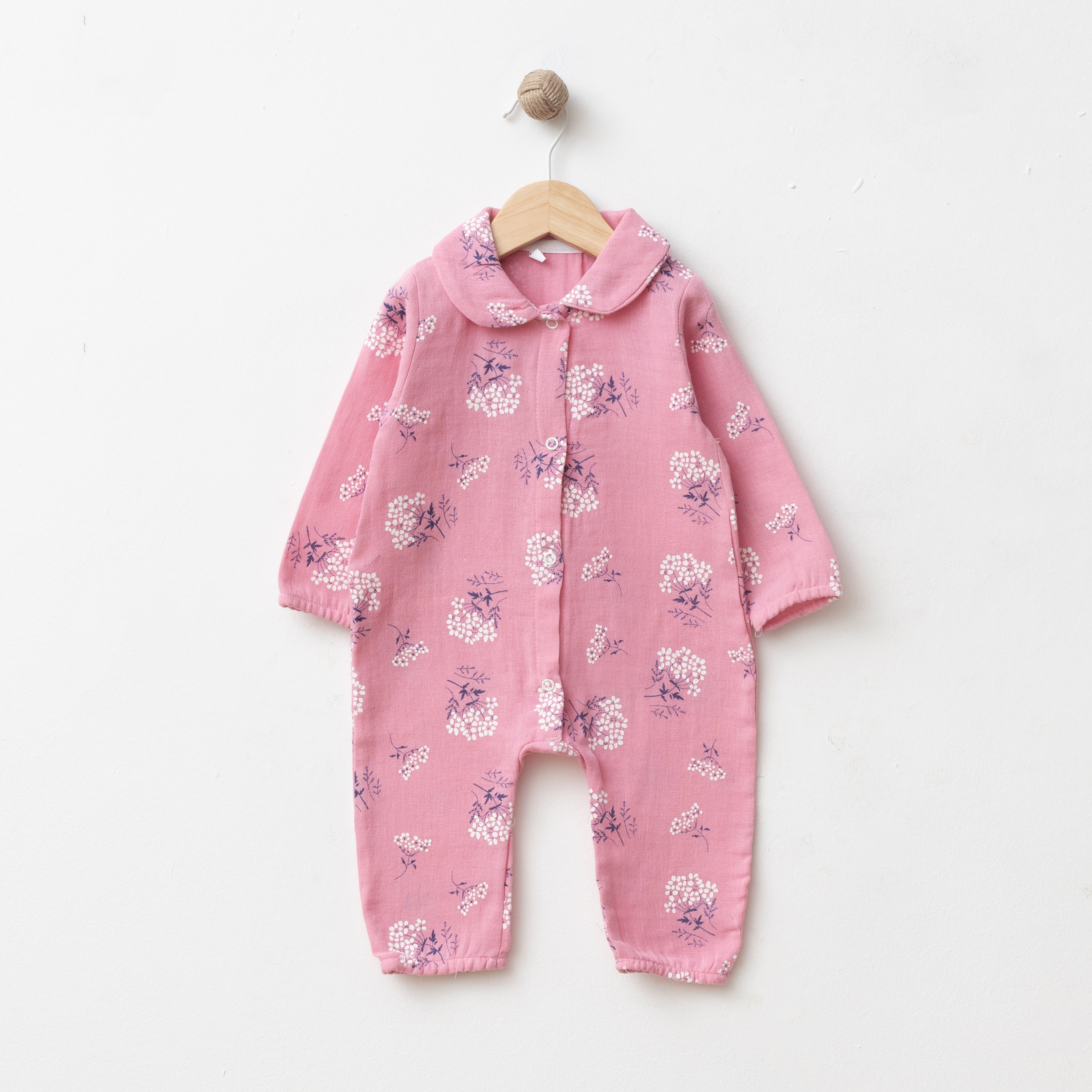 Wholesale GOTS-certified 100% cotton floral baby girl romper with rounded collar and front snap buttons, available in 3 to 12 months