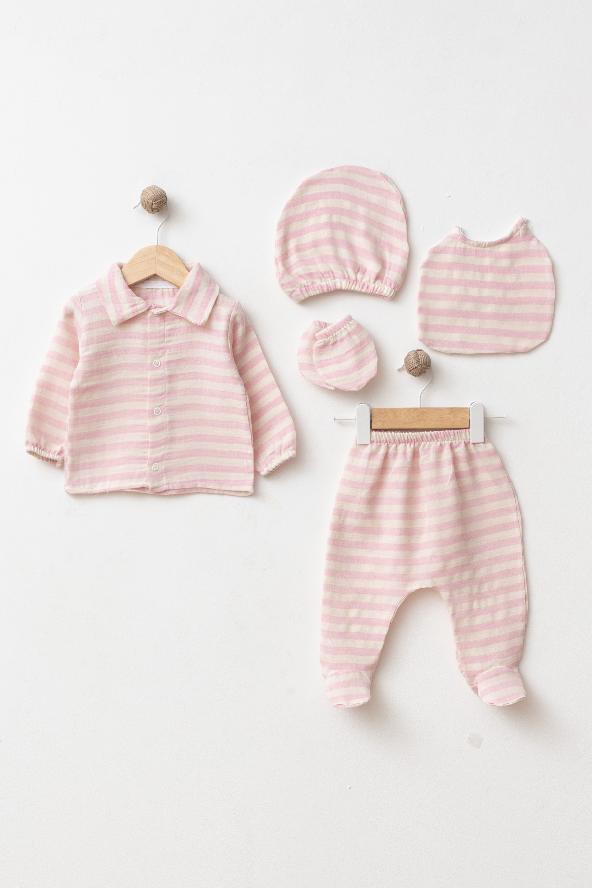 Wholesale 5-piece GOTS-certified cotton newborn baby girl hospital set with button-front top, footed trousers, matching hat, bib and mittens.